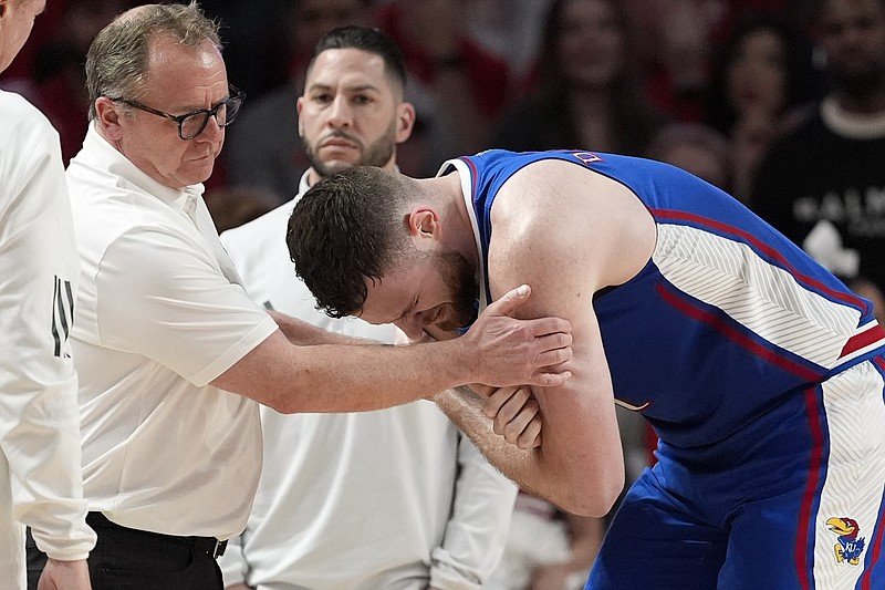 AP photo by David J. Phillip / Kansas center Hunter Dickinson, right, is helped after being injured during the Jayhawks' 76-46 loss at Houston in a Big 12 regular-season matchup last Saturday.