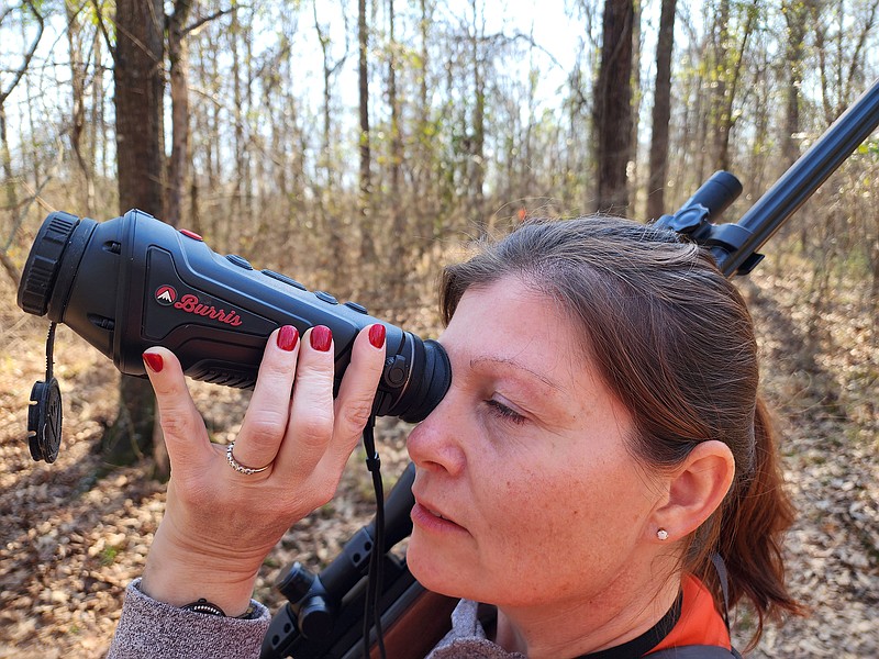 Contributed photo / Squirrel hunter Angie Perry takes a look through a Burris thermal monocular. Some hunters use devices such as monoculars or rifle-mounted scopes that utilize thermal imaging to spot and track game based on their body heat.