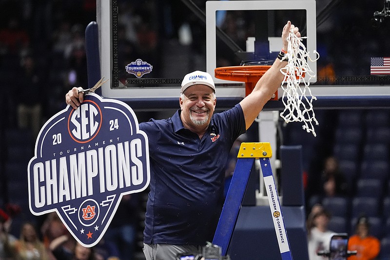 AP photo by John Bazemore / Auburn men's basketball coach Bruce Pearl holds up the net in celebration after the Tigers beat Florida to win the SEC tournament final Sunday at Nashville's Bridgestone Arena.