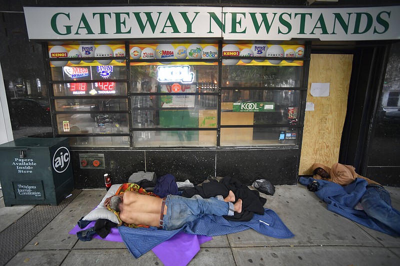 Homeless men sleep on Marietta Street in Atlanta on June 5, 2020. An audit revealed that a statewide council may be necessary to provide a coordinated response to the 4.4% growth in Georgia's homeless population from 2020. (AP Photo/Mike Stewart, File)