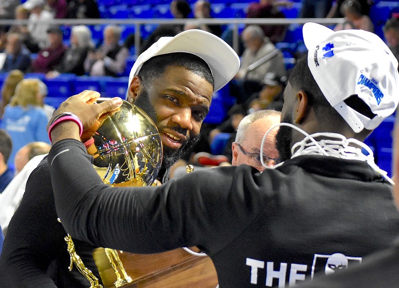 Staff photo by Patrick MacCoon / Chattanooga Prep basketball coach Christian Collins, right, and his twin brother Christoffer Collins hold the team's gold ball state championship trophy after the Sentinels won the TSSAA Class 1A title last Saturday in Murfreesboro.