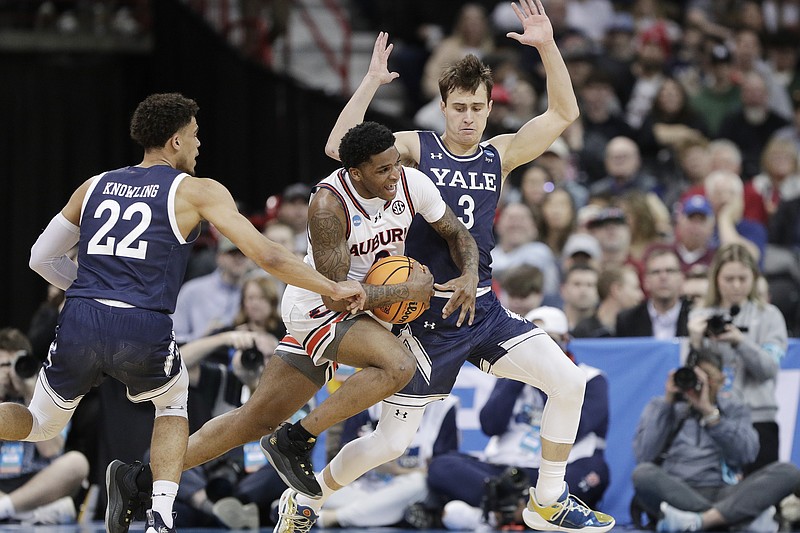 AP photo by Young Kwak / Auburn guard K.D. Johnson, center, drives while pressured by Yale forward Matt Knowling (22) and guard August Mahoney during an NCAA tournament first-round game Friday night in Spokane, Wash.