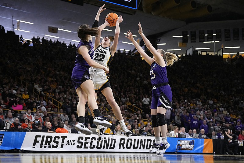 AP photo by Matthew Putney / Iowa's Caitlin Clark drives to the basket while double-teamed by Holy Cross guards Kaitlyn Flanagan, left, and Bronagh Power-Cassidy during an NCAA tournament first-round game Saturday in Iowa City.