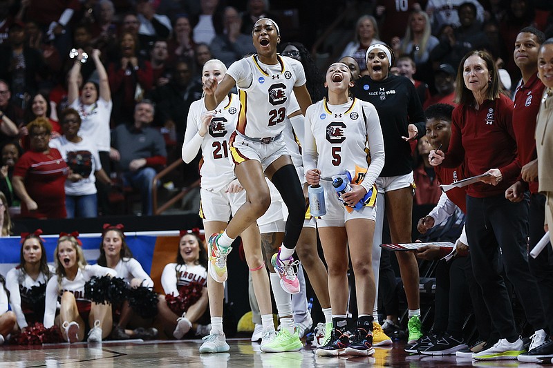 AP photo by Nell Redmond / South Carolina forward Chloe Kitts (21) and guards Bree Hall (23) and Tessa Johnson react as their team scores against North Carolina during an NCAA tournament second-round game Sunday in Columbia, S.C.
