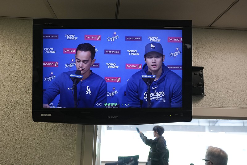 A video screen displays Los Angeles Dodgers' Shohei Ohtani, right, and interpreter Will Ireton during a news conference at Dodger Stadium in Los Angeles, Monday, March 25, 2024. (AP Photo/Jae C. Hong)