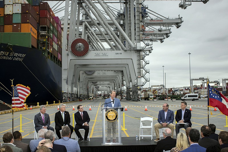 In this photo provided by the Georgia Port Authority, Georgia Gov. Brian Kemp, center, speaks during a visit to the Port of Savannah with U.S. Reps. Sam Graves, R-Ga., center left, Buddy Carter, R-Ga., left, and Mike Collins, R-Ga., center left, at the Georgia Ports Authority's Garden City Terminal, Monday, March, 25, 2024, in Savannah, Ga. The Georgia Ports Authority has been pushing for Congress to consider another round of deepening Savannah's shipping channel. The agency's leaders say ever-growing classes of enormous cargo ships need even deeper water to be able to reach the port with full loads during lower tides. (Stephen B. Morton/Georgia Port Authority via AP)