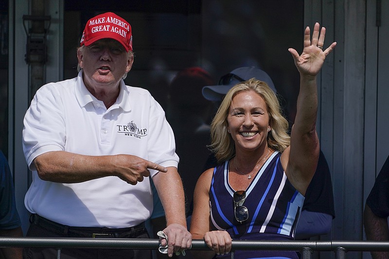 File photo/Seth Wenig/The Associated Press / Rep. Marjorie Taylor Greene, R-Ga., waves while former President Donald Trump points to her while they look over the 16th tee during the second round of the Bedminster Invitational LIV Golf tournament on July 30, 2022, in Bedminster, N.J.