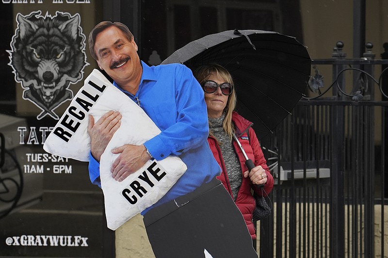 Stacy Oliver holds display of Mike Lindell, the controversial CEO of My Pillow who has advocated falsehoods about the 2020 presidential election, during a rally in Redding, Calif., on Tuesday, Feb. 20, 2024. Oliver supports recalling Shasta County Supervisor Kevin Crye from office. Crye is one of the board members who voted to get rid of the county's ballot-counting machines in favor of counting ballots by hand. Crye had previously met with Lindell, an action that angered some voters. (AP Photo/Rich Pedroncelli)