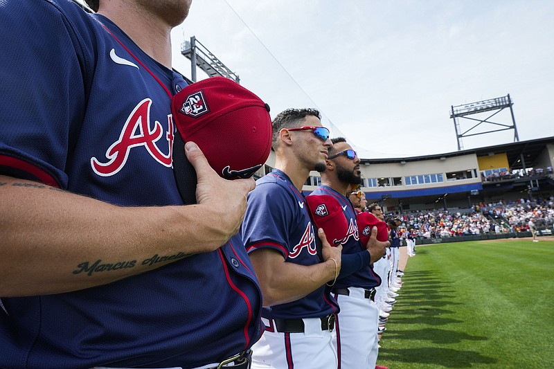 AP photo by Gerald Herbert / The Atlanta Braves line up for the national anthem before a spring training game against the Detroit Tigers on March 5 in North Port, Fla.