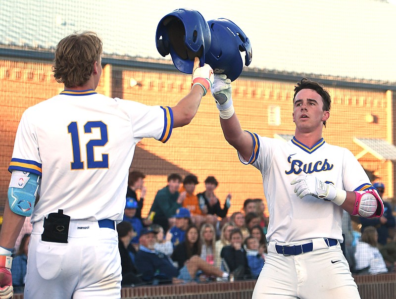 Staff photo by Robin Rudd / Boyd Buchanan's Cooper Jones (12) touches helmets in celebration with Brodie Johnston, who had just hit a solo home run for the Buccaneers in Thursday's game against visiting Walker Valley. Boyd Buchanan won 6-3 to improve to 10-1.
