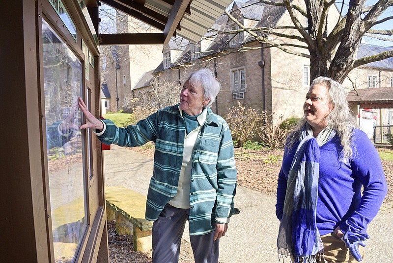 Staff File Photo by Robin Rudd / Lisa Lemza, left, and Kristina Shaneyfelt consult the informational display that maps each tree in the arboretum at Grace Episcopal Church.