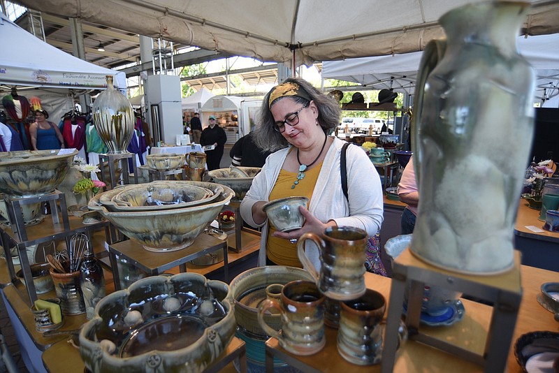 Staff file photo by Matt Hamilton / Chattanooga resident Tonia Durand looks over pottery in a booth during last year's 4 Bridges Arts Festival at First Horizon Pavilion. This year's festival will be held April 20-21.