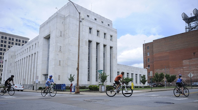 Staff File Photo / Four cyclists wheel past the Joel W. Solomon Federal Building and onto East 10th Street in this June 9, 2014, photo.