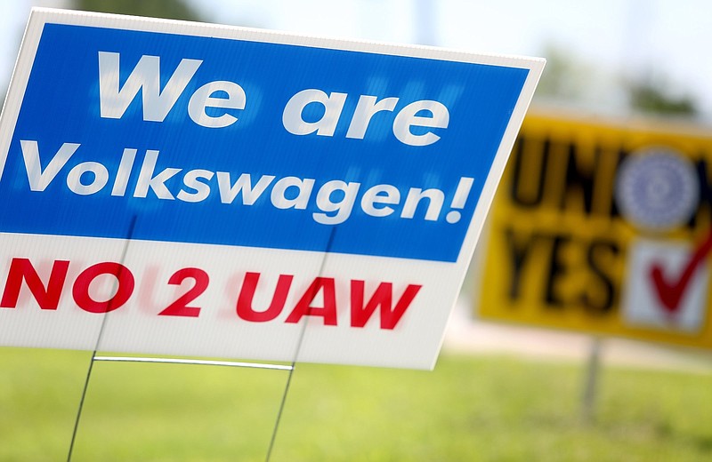 Staff file photo / Signs for and against unionization are in a roundabout along Volkswagen Drive in front of the Volkswagen plant on June 14, 2019 in Chattanooga, Tennessee.