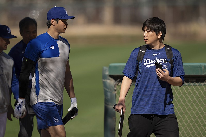 AP photo by Carolyn Kaster / Los Angeles Dodgers player Shohei Ohtani, left, walks with Ippei Mizuhara, his interpreter at the time, during spring training on Feb. 12 in Phoenix.