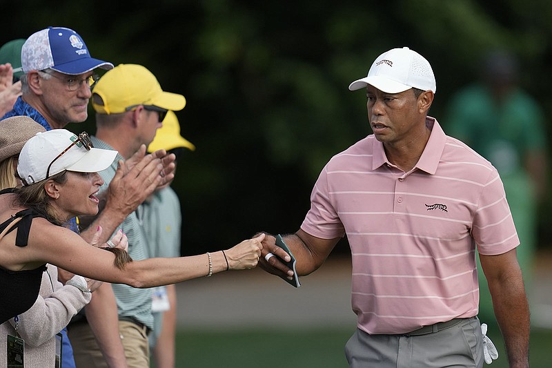 AP photo by Ashley Landis / Tiger Woods greets a fan on the sixth hole at Augusta National Golf Club during the first round of the Masters on Thursday.