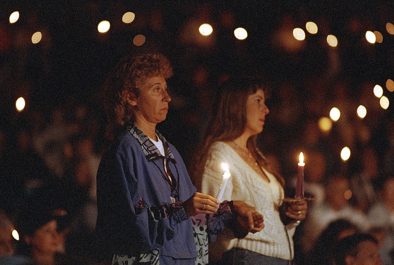 File photo/Tammy Lechner/The Associated Press / Two unidentified women join a crowd of about 400 gathered to commemorate the two-year anniversary of the death of Nicole Brown Simpson with a candlelight vigil at Salt Creek Beach in Dana Point, Calif., on Wednesday, June 12, 1996.