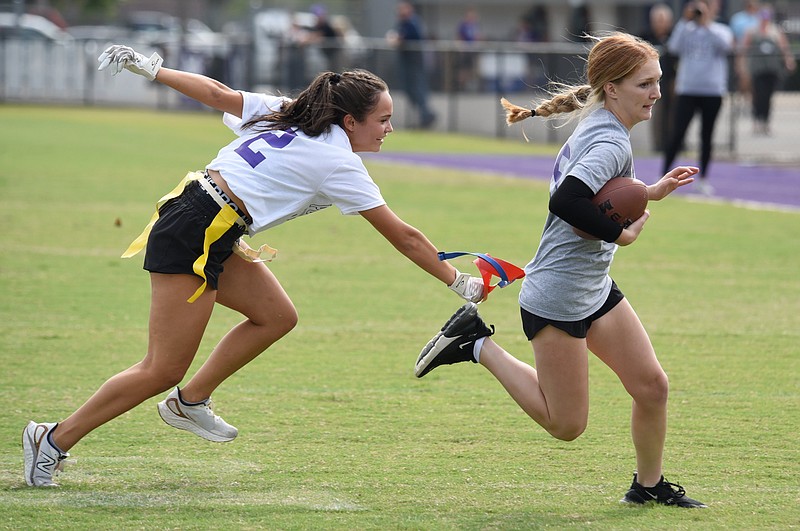 Staff photo by Matt Hamilton / Marion County junior Ayla Flintz, left, reaches for sophomore Jacy Gatlin's flag during a powder puff football game between the sophomores and juniors in October 2023. Money raised from ticket sales went to the high school's prom fund.