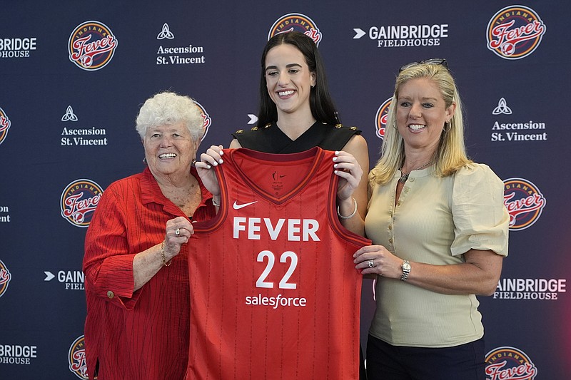 AP photo by Darron Cummings / WNBA No. 1 overall draft pick Caitlin Clark, middle, poses with Indiana Fever general manager Lin Dunn, left, and head coach Christie Sides after the rookie guard's introductory news conference Wednesday in Indianapolis.