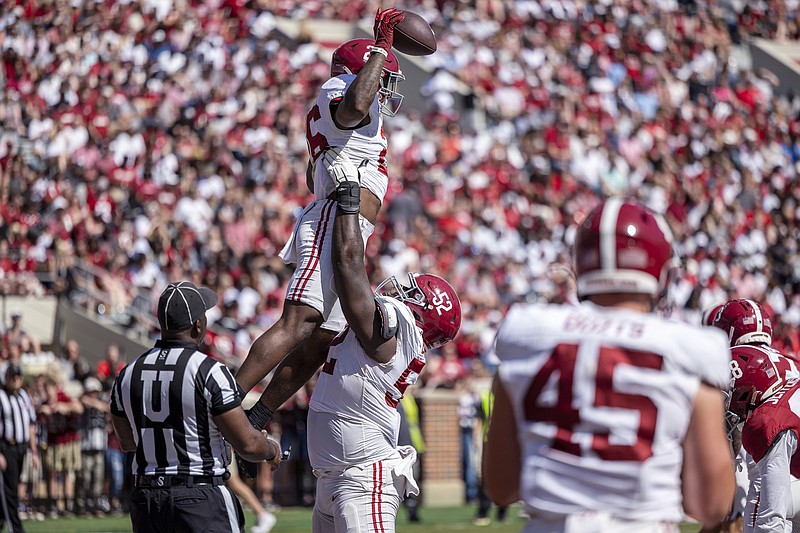 AP photo by Vasha Hunt / Alabama running back Jam Miller is lifted by offensive lineman Tyler Booker after scoring a touchdown during the Crimson Tide's A-Day spring game on April 13 in Tuscaloosa.