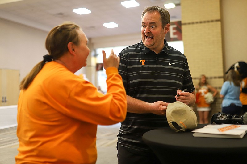 Staff photo by Olivia Ross / Tennessee football coach Josh Heupel laughs with Vols fan Dee Holt during a meet-and-greet session as part of the school's “Big Orange Caravan” stop at the Chattanooga Convention Center on Wednesday night.