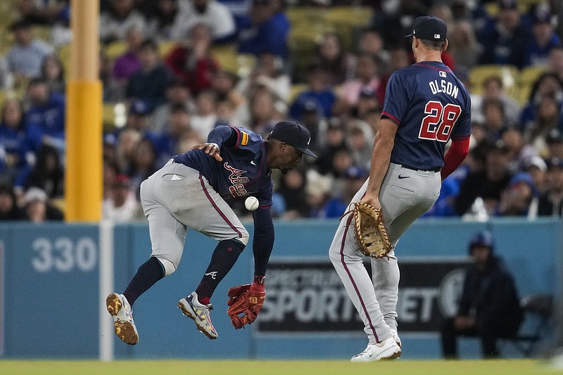 AP photo by Ashley Landis / Atlanta Braves first baseman Matt Olson, right, watches as second baseman Ozzie Albies is unable to catch a fly ball hit by the Los Angeles Dodgers' Mookie Betts in the seventh inning Saturday night.