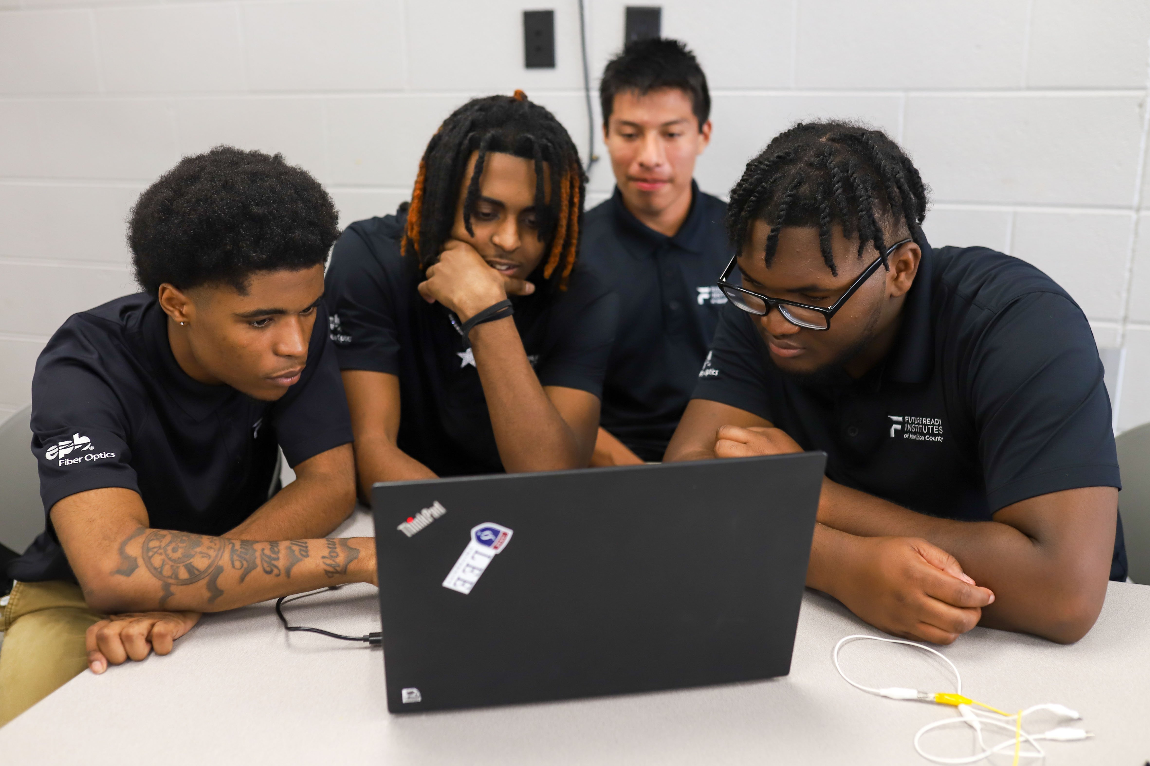 Staff photo by Olivia Ross / From left, Maurice Ellison, Qwanelle Lowe, Adrian Vazquez and Cameron Tucker work together to show their project at Tyner Academy. EPB Future Ready Institute of Technology and Networking students demonstrated their creations during Tyner's World Quantum Day showcase on Tuesday.