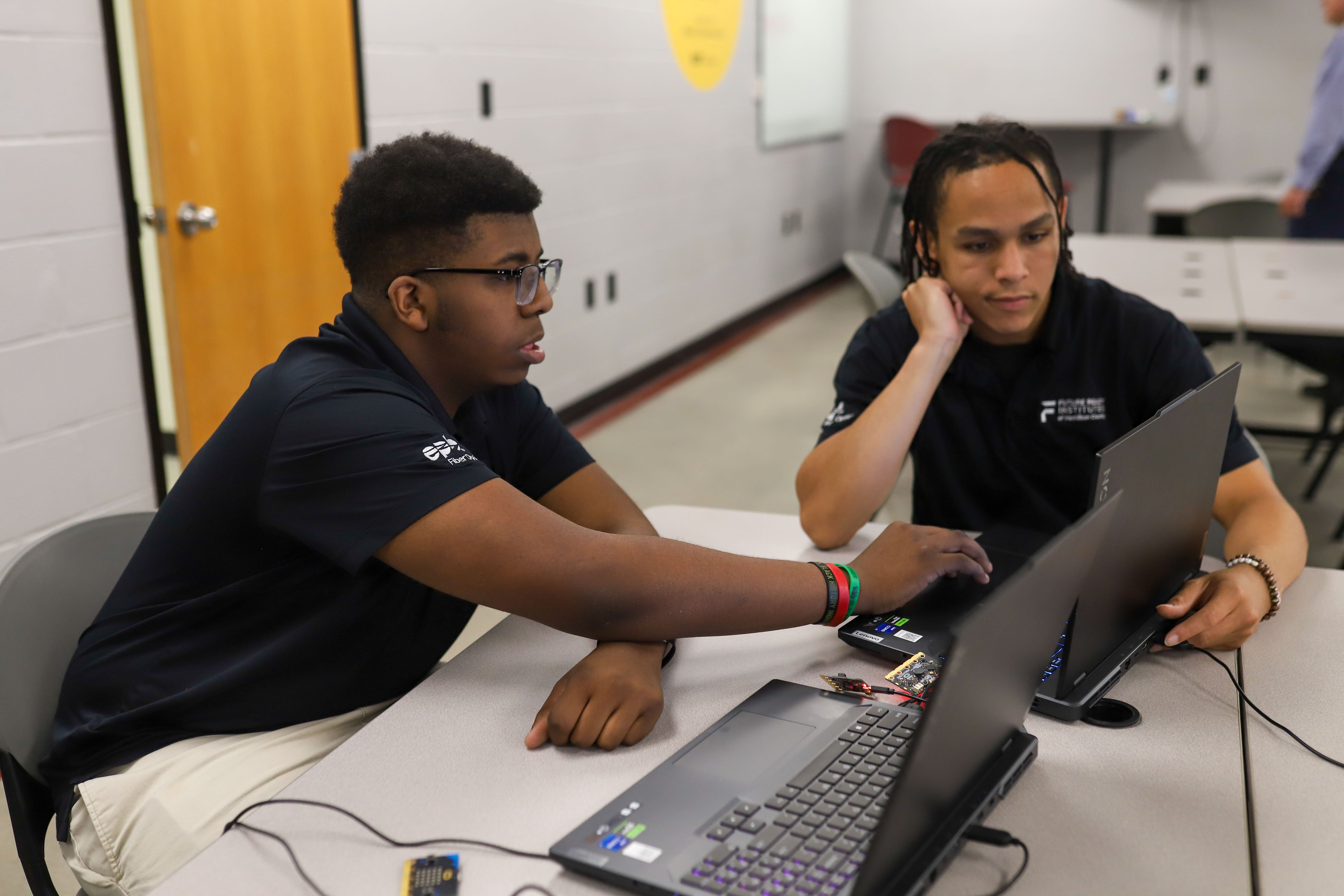 Staff photo by Olivia Ross / Treyvious Lansden, left, and Elijah Smith help each other with their work at Tyner Academy. EPB Future Ready Institute of Technology and Networking students demonstrated their creations during Tyner's World Quantum Day showcase on Tuesday.