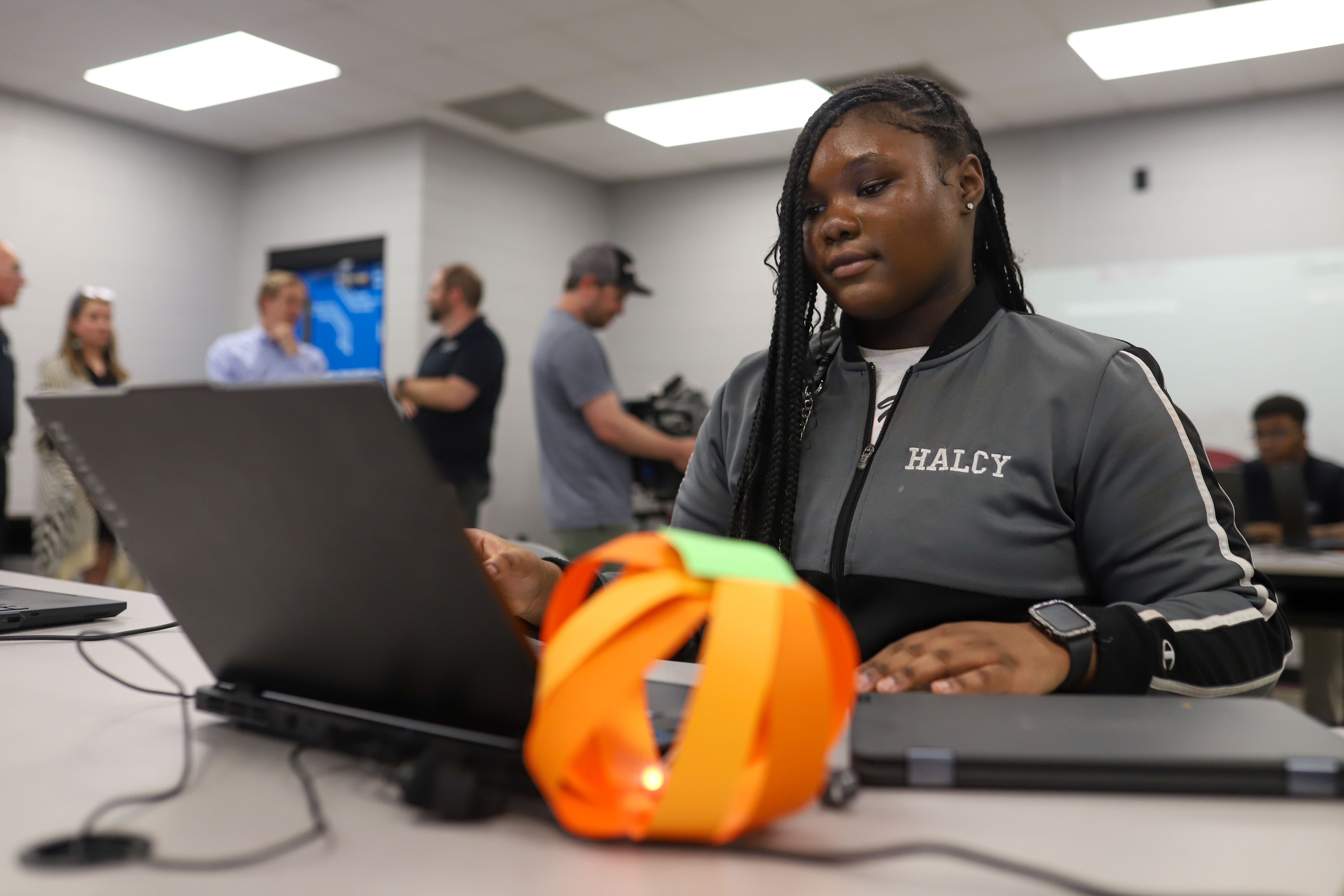 Staff photo by Olivia Ross / Halcyunna Upshaw lights up the pumpkin in front of her through her work at Tyner Academy. EPB Future Ready Institute of Technology and Networking students demonstrated their creations during Tyner's World Quantum Day showcase on Tuesday.