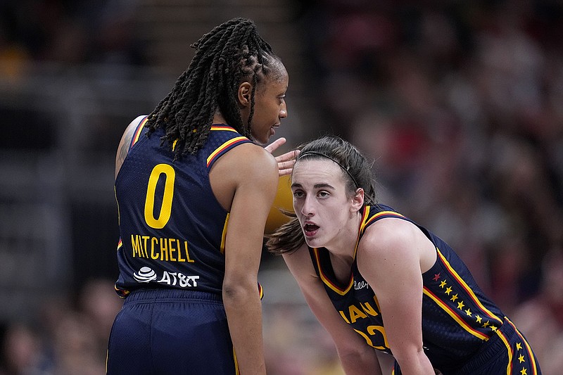 AP photo by Michael Conroy / Indiana Fever guard Kelsey Mitchell talks with rookie teammate Caitlin Clark during the team's regular-season home opener against the New York Liberty on Thursday night in Indianapolis.
