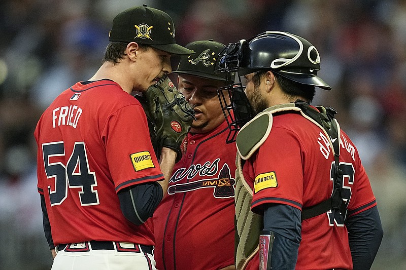 AP photo by Mike Stewart / Atlanta Braves pitcher Max Fried (54) speaks with bullpen coach Erick Abreu, center, and catcher Travis d'Arnaud on the mound during the third inning of Friday night's home game against the San Diego Padres.