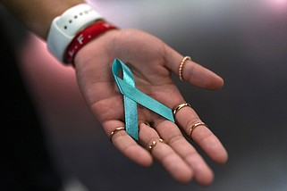 Sarah Barber shows a ribbon given to her by sexual abuse survivors at the Southern Baptist Convention's annual meeting in Anaheim, Calif., Tuesday, June 14, 2022. (AP Photo/Jae C. Hong)