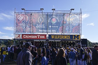 AP photo by Ryan Sun / College football fans walk outside the stadium before Alabama and Michigan meet in the Rose Bowl semifinal on Jan. 1 in Pasadena, Calif.