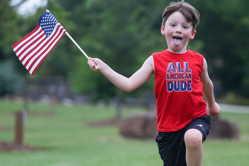 Staff file photo by Olivia Ross / Gavin Wagner waves a flag at the 2023 Freedom Festival in Collegedale. This year's event, featuring patriotic music by the East Tennessee Symphony Orchestra, is July 3.