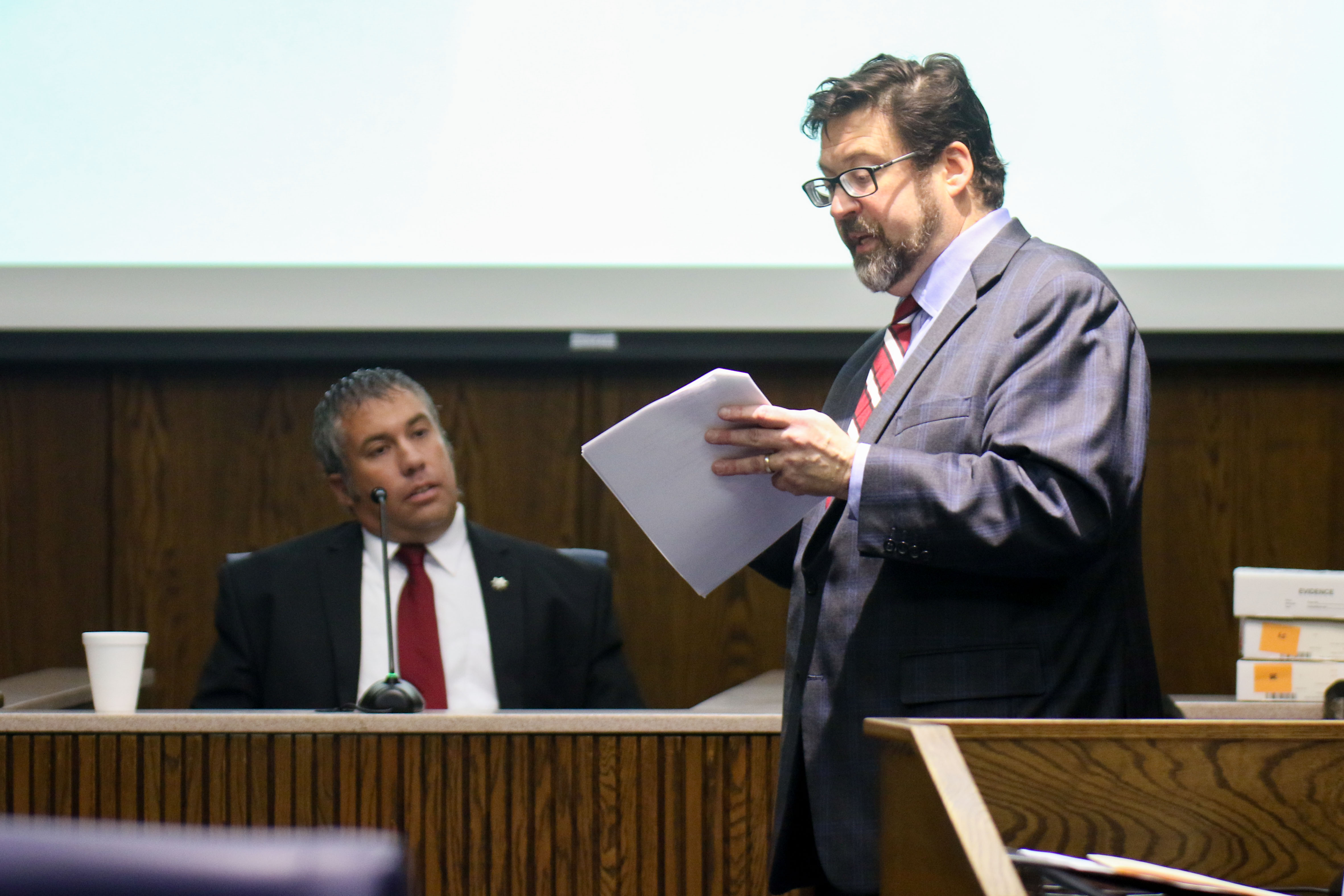 Staff photo by Olivia Ross / Raymond Rzeplinski's attorney Ben McGowan, right, speaks with Sgt. Jason Maucere during court Wednesday at the Courts Building in Chattanooga.
