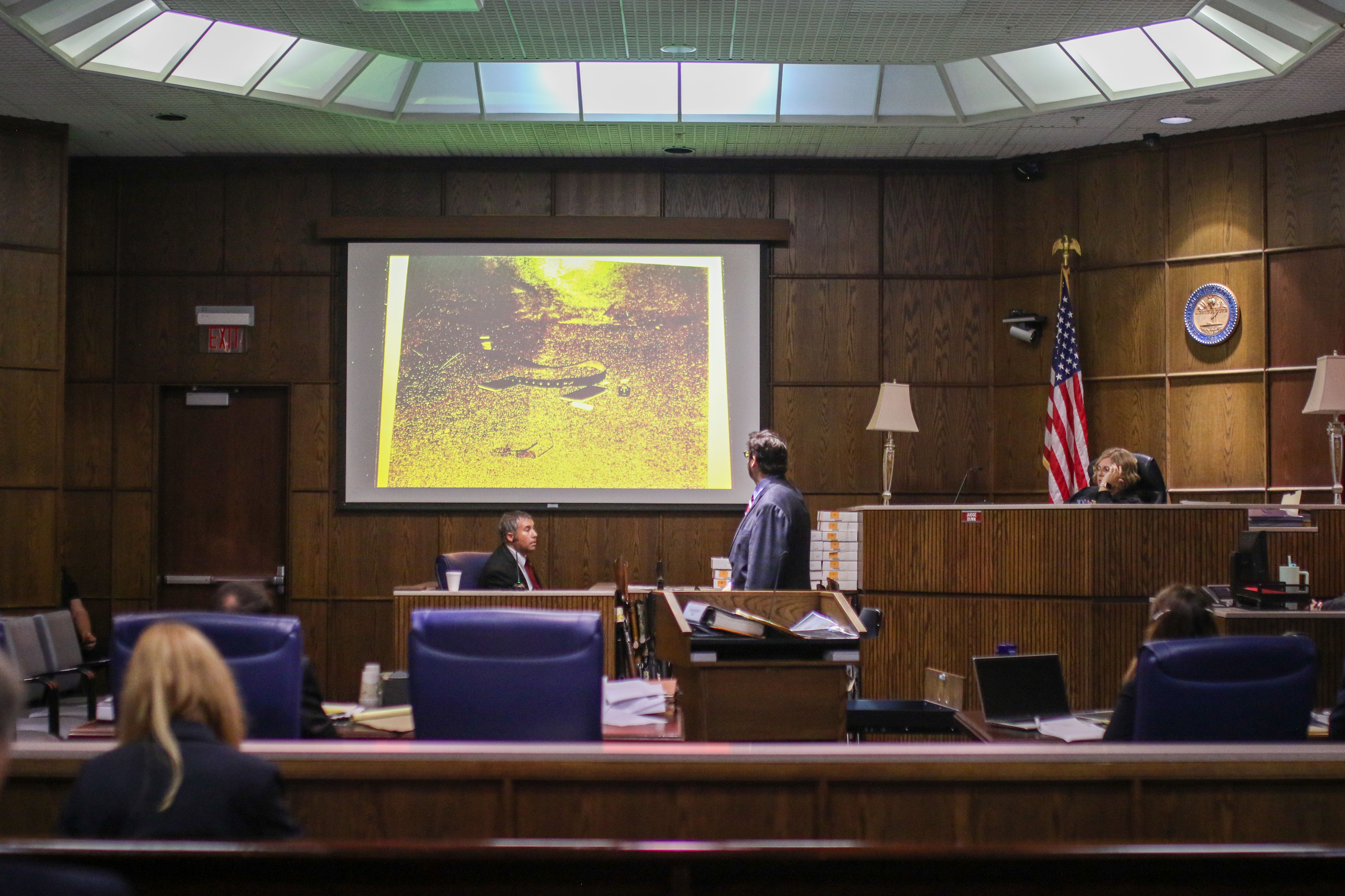 Staff photo by Olivia Ross / Raymond Rzeplinski's attorney Ben McGowan, standing, speaks with Sgt. Jason Maucere during court Wednesday at the Courts Building in Chattanooga.