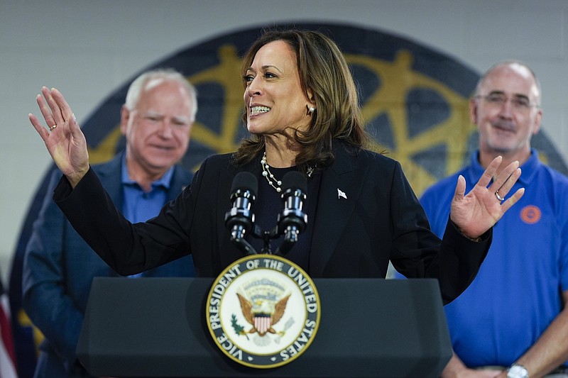 照片/Julia Nikhinson/美联社/民主党总统候选人副总统卡马拉·哈里斯与民主党副总统候选人明尼苏达州州长蒂姆·沃尔兹（左）和美国汽车工人联合会主席肖恩·费恩于 2024 年 8 月 8 日星期四在密歇根州韦恩市美国汽车工人联合会地方 900 号分会的竞选集会上发表讲话。