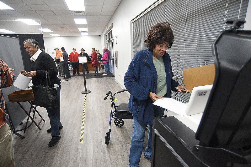Staff photo by Matt Hamilton / Former Tennessee state Rep. JoAnne Favors, right, casts the first ballot of early voting Oct. 16, 2024, at the Hamilton County Election Commission.