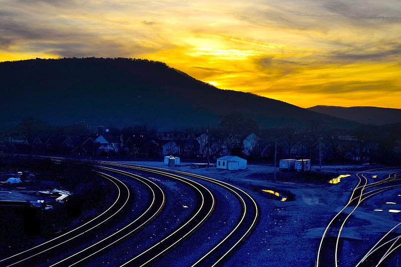 Staff File Photo by Robin Rudd / In this view from the Central Avenue Bridge, the sun sets behind Lookout Mountain and the last light glows up the tracks that serve both Norfolk Southern and CSX railways.