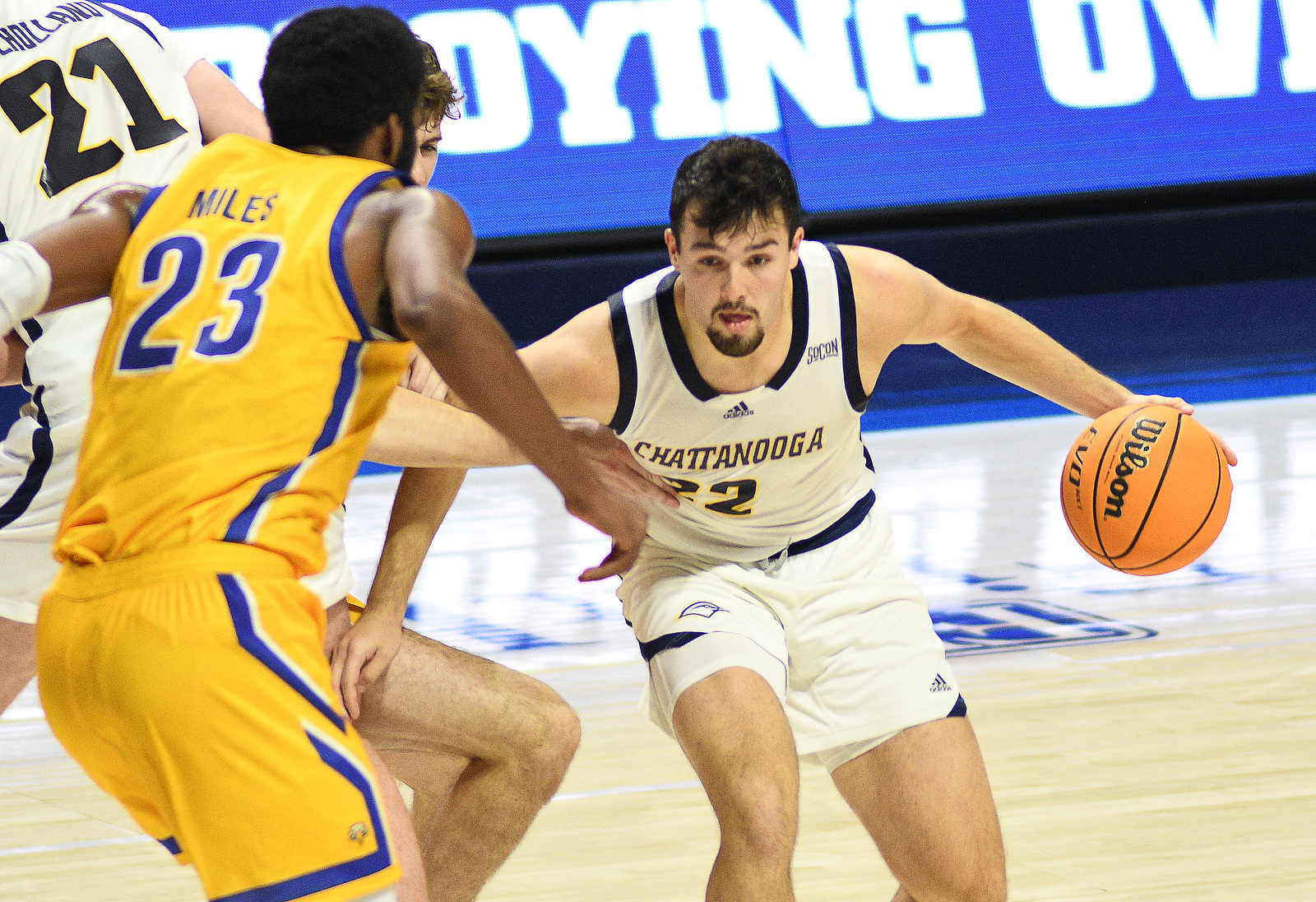 Staff photo by Robin Rudd / UTC's Bash Wieland, right, moves around the pick set by teammate Collin Mullholand (21) and toward Morehead State's Dieonte Miles (23) during Thursday night's game at McKenzie Arena.