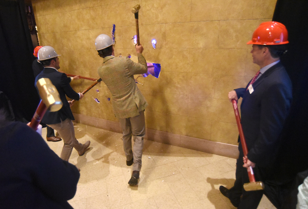 Staff photo by Matt Hamilton / Hamilton County Mayor Weston Wamp (left) and Chattanooga Mayor Tim Kelly (center) knock through a wall Dec. 17, 2024, during a ceremony to mark the official start of the Tivoli Theatre renovation.