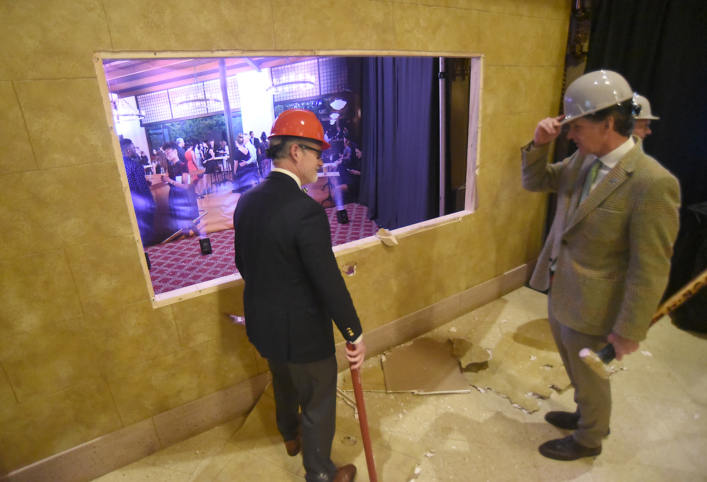Staff photo by Matt Hamilton / Chattanooga Mayor Tim Kelly, right, looks through a hole in a wall Dec. 17, 2024, during a ceremony to mark the official start of the Tivoli Theatre renovation project.