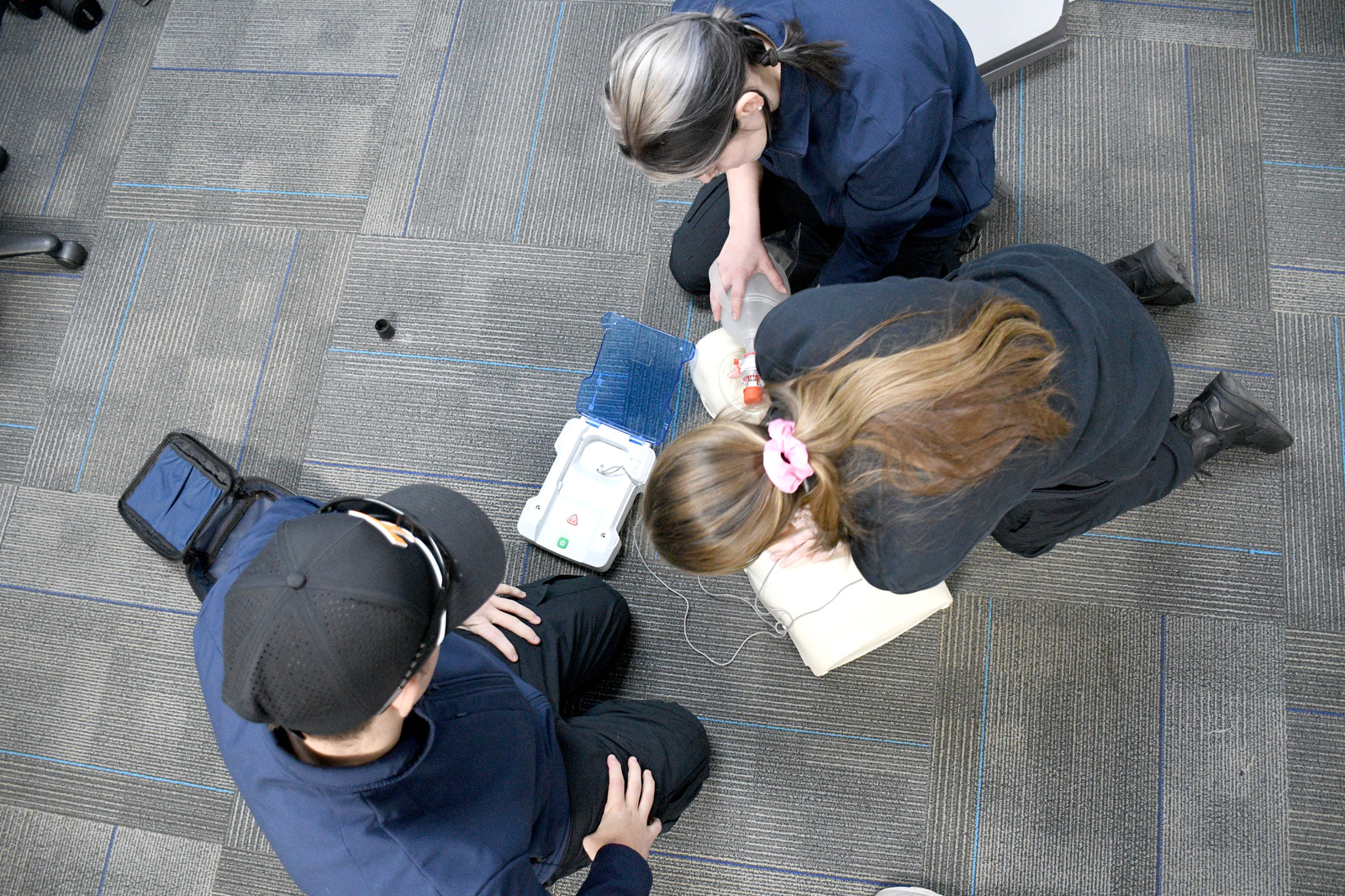 Staff Photo by Robin Rudd / From left, Bradley Dowlen, Maggie Nunley and Abigail Christensen practice CPR with a training manikin Jan. 22, 2025. Starting this school year, Hixson High students can receive hands-on training at Hamilton County's EMS Training Center.