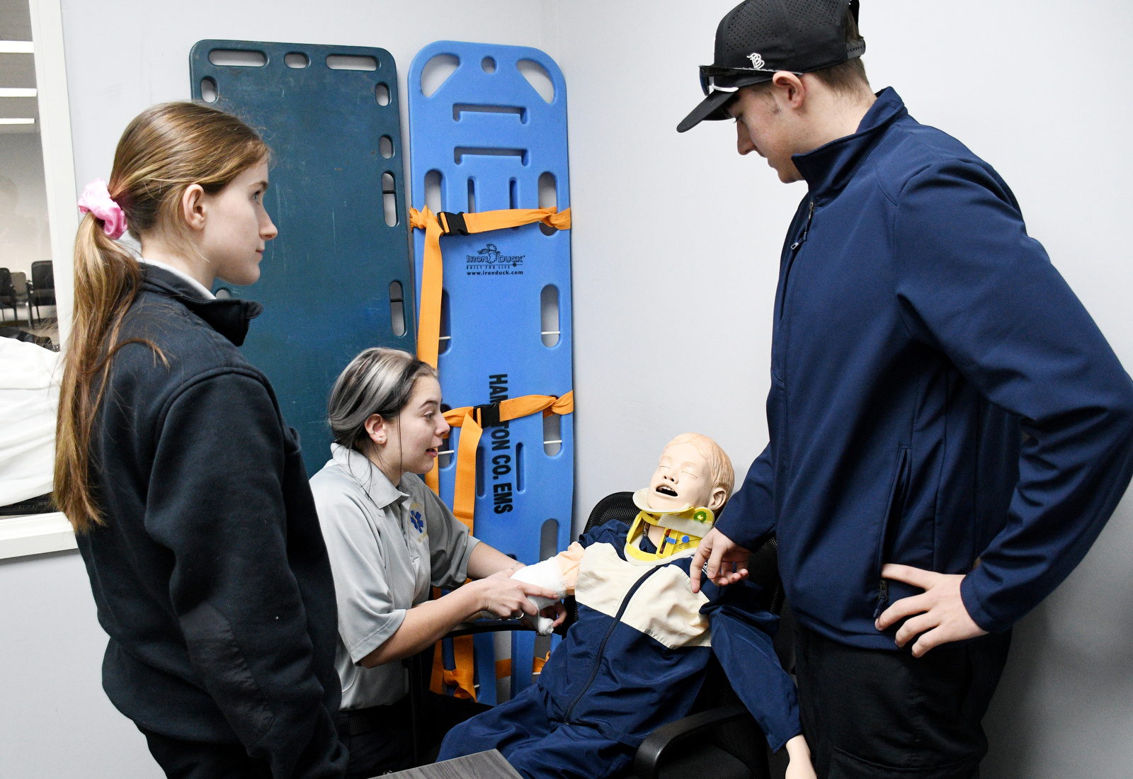 Staff Photo by Robin Rudd / Student Abigail Christensen wraps a pediatric manikin's arm Jan. 22, 2025, during a wound dressing exercise, as Maggie Nunley and Bradley Dowlen observe. Starting this school year, Hixson High students can receive hands-on training at Hamilton County's EMS Training Center.