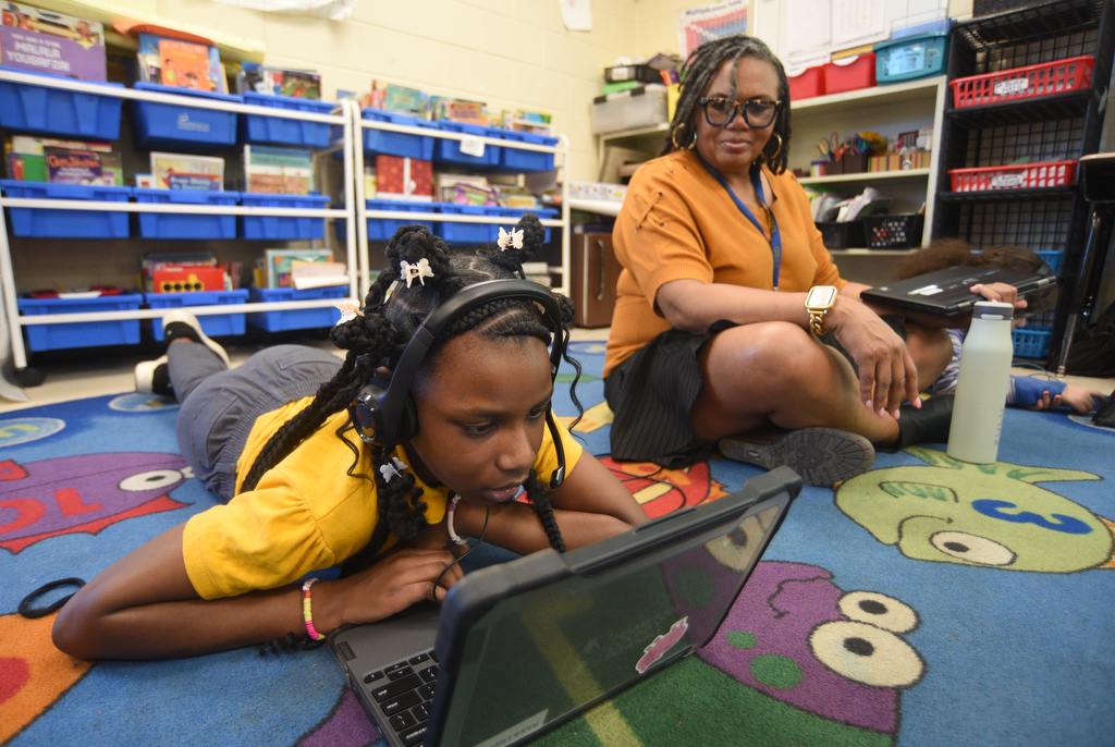 Staff photo by Matt Hamilton/ Assistant principal Megan Bray looks on as Rikiya Lloyd works with a tutor via video chat during a class at Orchard Knob Elementary School on Tuesday, March 11, 2025.