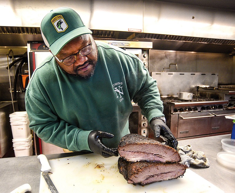 Staff photo by Matt Hamilton / Brandon Ellis serves up smoked beef brisket at the Chatter Box Cafe.
