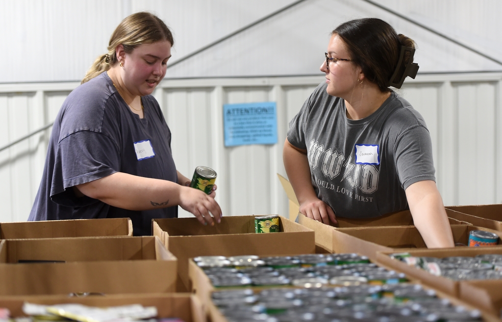Staff photo by Matt Hamilton/ Volunteers Avery Freeman, left, and Savannah Boyle pack food into boxes for distribution at the Chattanooga Area Food Bank on Friday, April 4, 2025.
