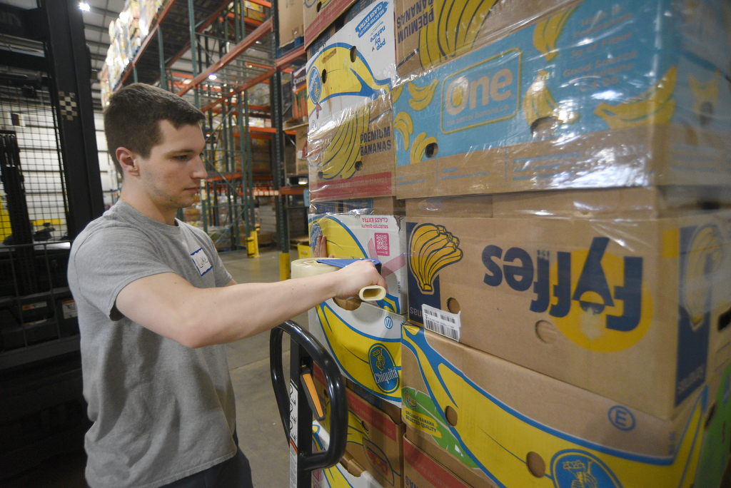 Staff photo by Matt Hamilton/ Volunteer Luke Williams secures a stack of boxes filled with food at the Chattanooga Area Food Bank on Friday, April 4, 2025.