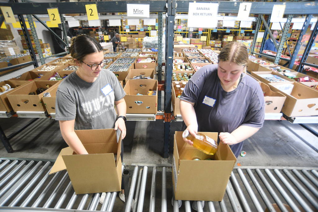 Staff photo by Matt Hamilton/ Volunteers Avery Freeman, right, and Savannah Boyle pack food into boxes for distribution at the Chattanooga Area Food Bank on Friday, April 4, 2025.