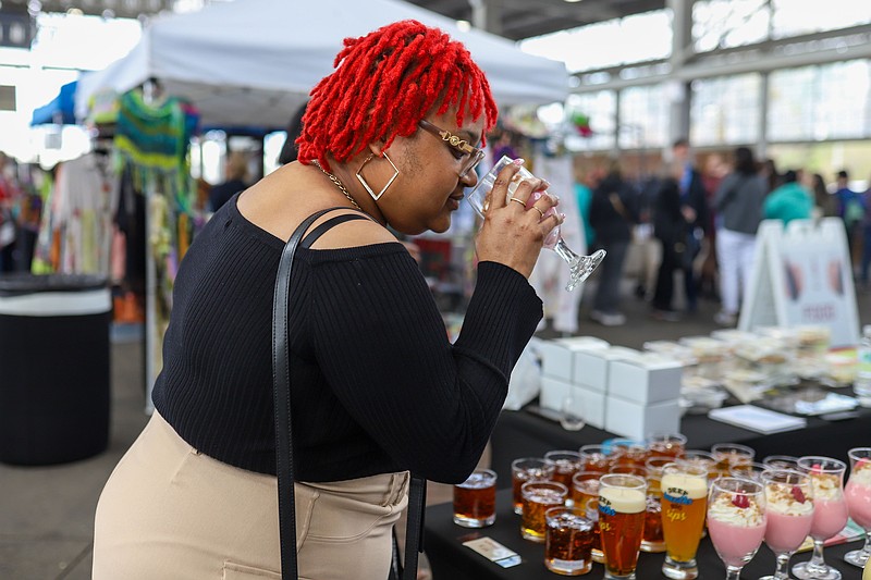Staff file photo / Kasandra Gladden smells a wine-shaped candle from Chattown Candles Co. at the 2024 Sip TN Wine Festival at First Horizon Pavilion. The venue will host this year's festival on April 19.